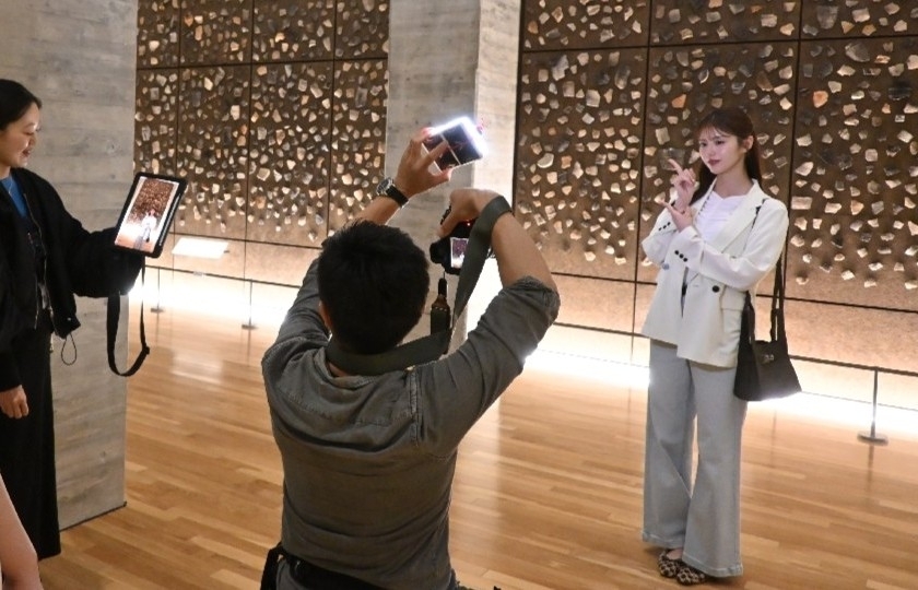 三内丸山遺跡で「旅色」の撮影に臨む鈴木ゆうかさん(右)=25日、青森市