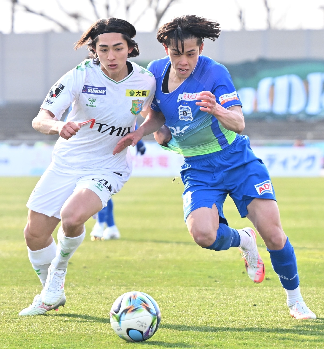 【ブラウブリッツ秋田―ヴァンラーレ八戸】後半、体を当てて相手の突破を阻むヴァンラーレＭＦの鈴木慎之介（左）＝ソユースタジアム