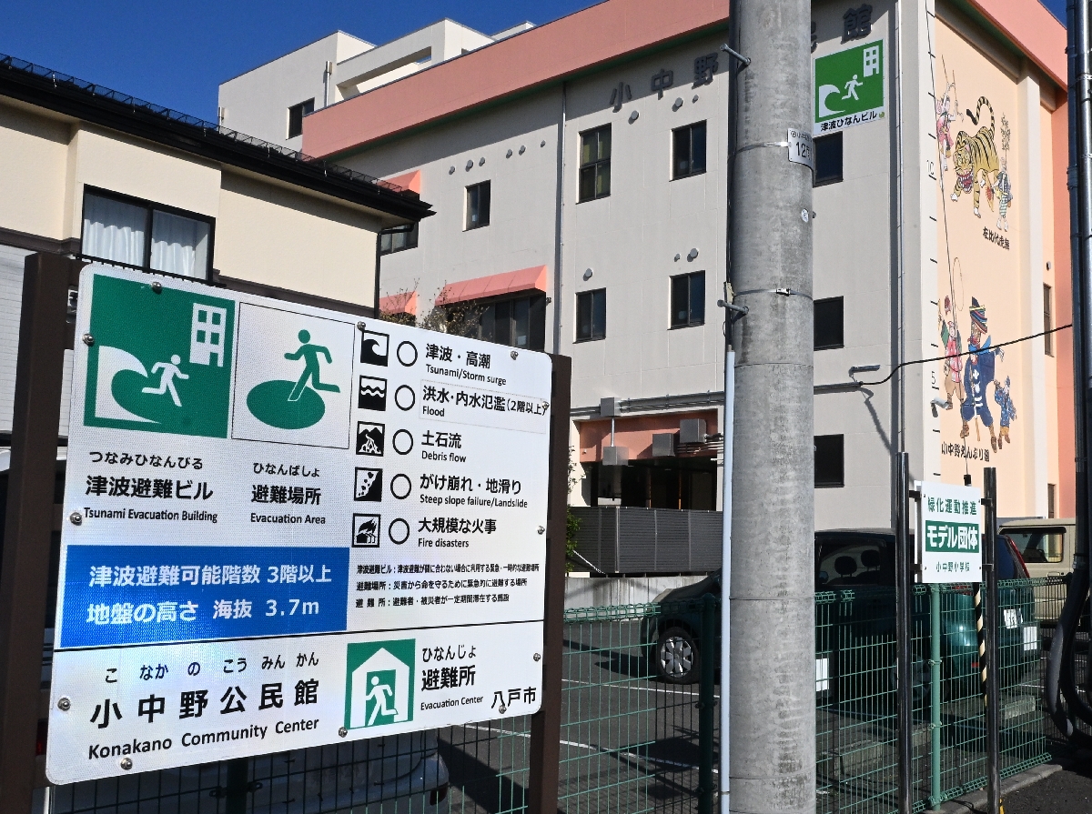 小中野公民館の前に立つ看板。津波警報発表時の初動開設避難所だが、記載は「避難所」のみだ＝２５日、八戸市