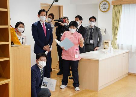 「産後ケア」の事業に取り組む東京都内の施設を視察する自民党の小林政調会長(左後方から2人目)=27日午前