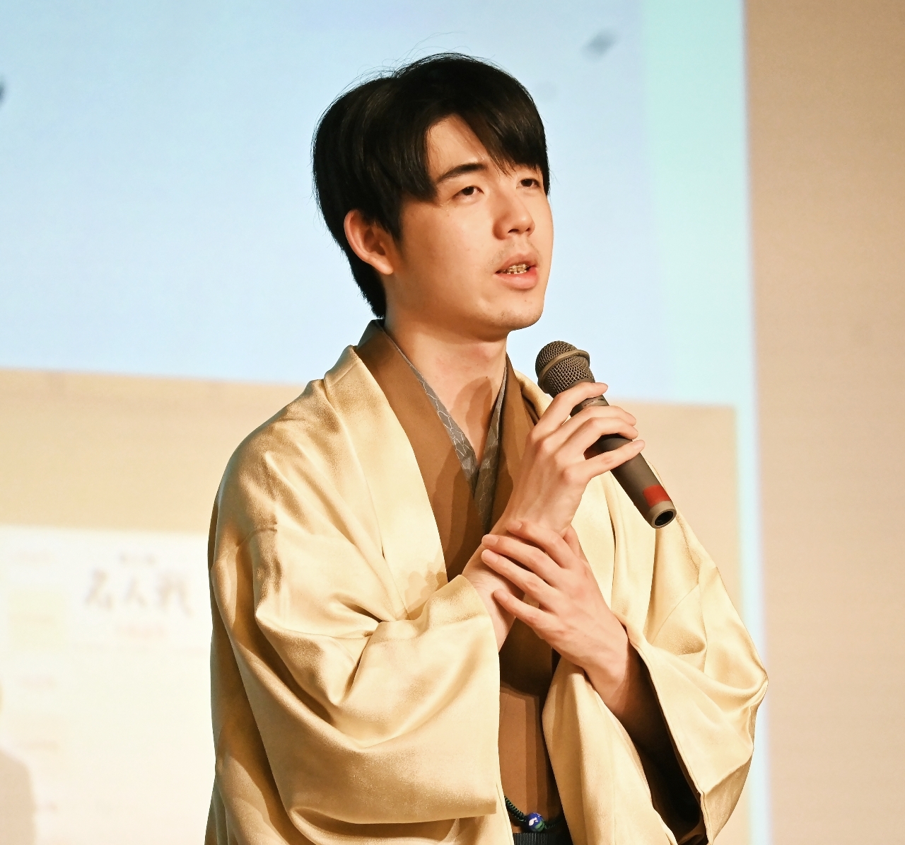 大盤解説に詰めかけた将棋ファンを前に第2局を振り返る藤井聡太名人=26日、青森市