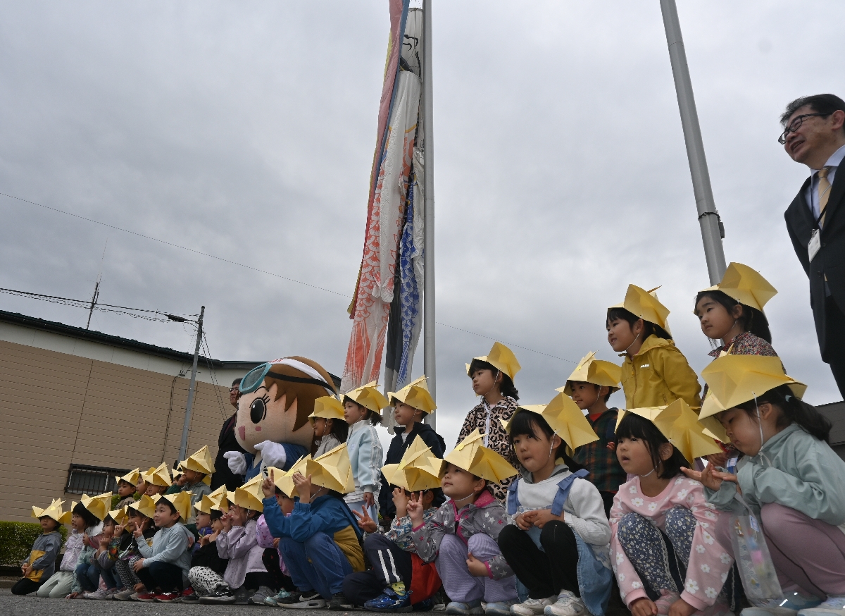 掲揚したこいのぼりの前で記念撮影する久慈保育園の園児
