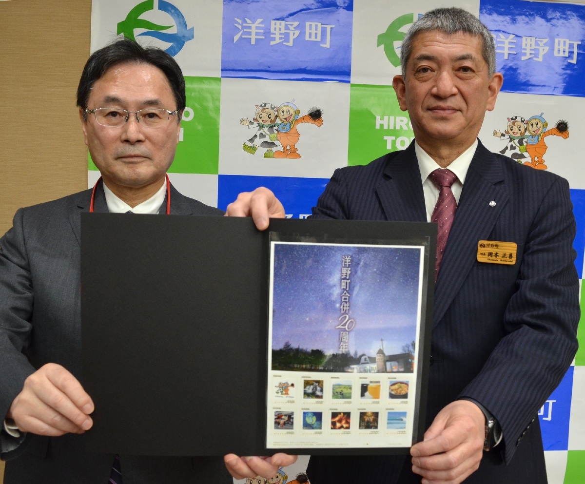 洋野町の合併20周年を記念したオリジナルフレーム切手を岡本正善町長(右)へ贈った稲葉恭也局長