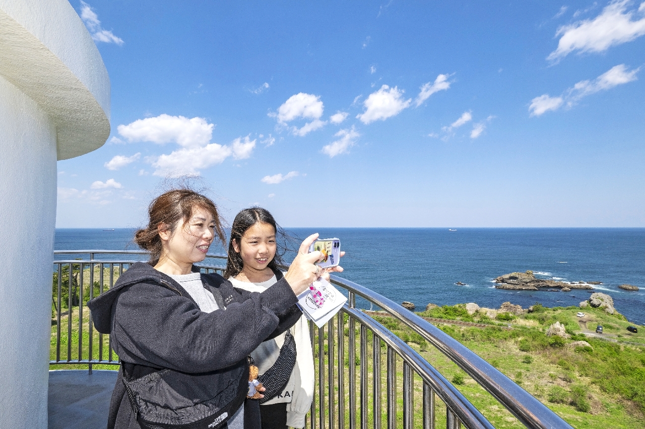 一般開放が始まっている鮫角灯台。眼下に広がる絶景を写真に収める来訪者＝５日、八戸市