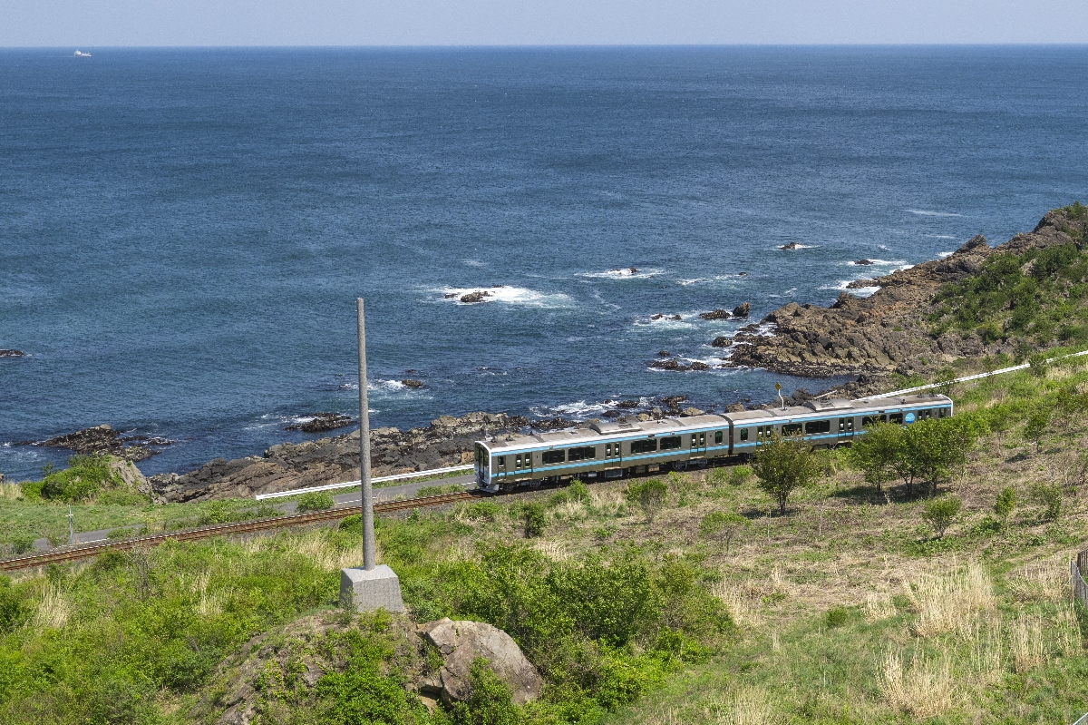灯台の眼下を走る八戸線の列車