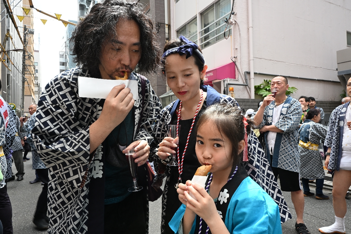 春巻きを頰張る祭りの参加者