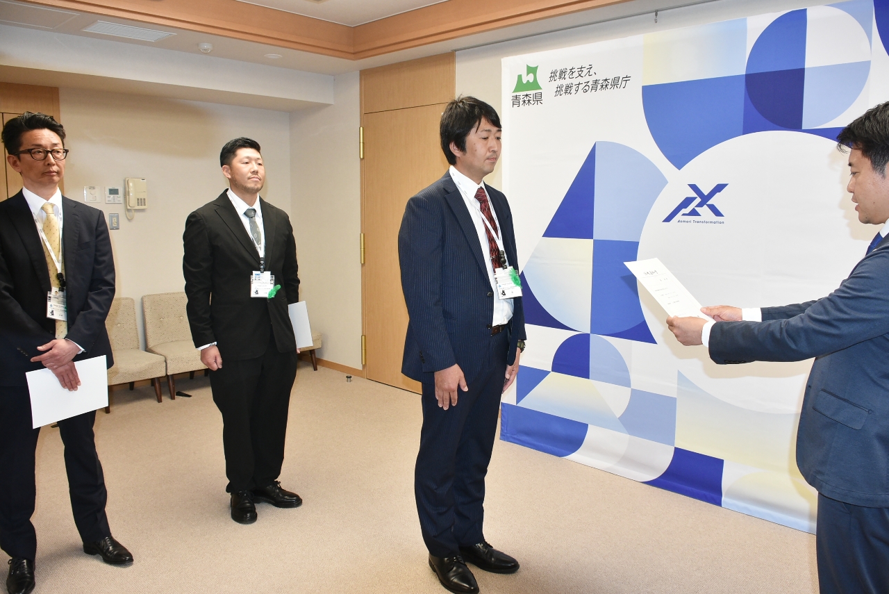 宮下宗一郎知事（右）から任命通知書を受ける盛英吾さん（右から２人目）ら＝８日、青森県庁