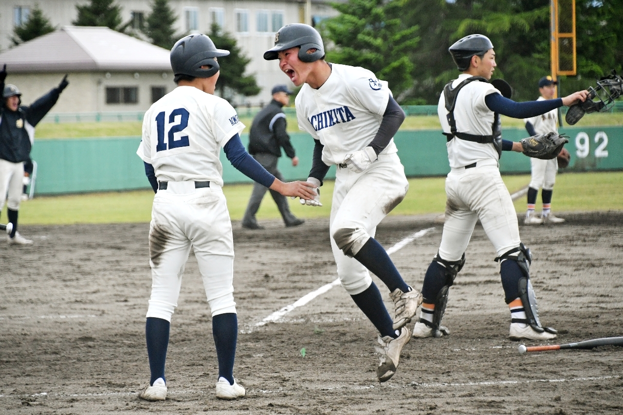 【1回戦・東奥学園―八戸北】5回八戸北2死二、三塁、内城司聖の安打で生還し、三走荒川央典(12)とタッチして喜ぶ二走廣瀬鴻志=黒石市営