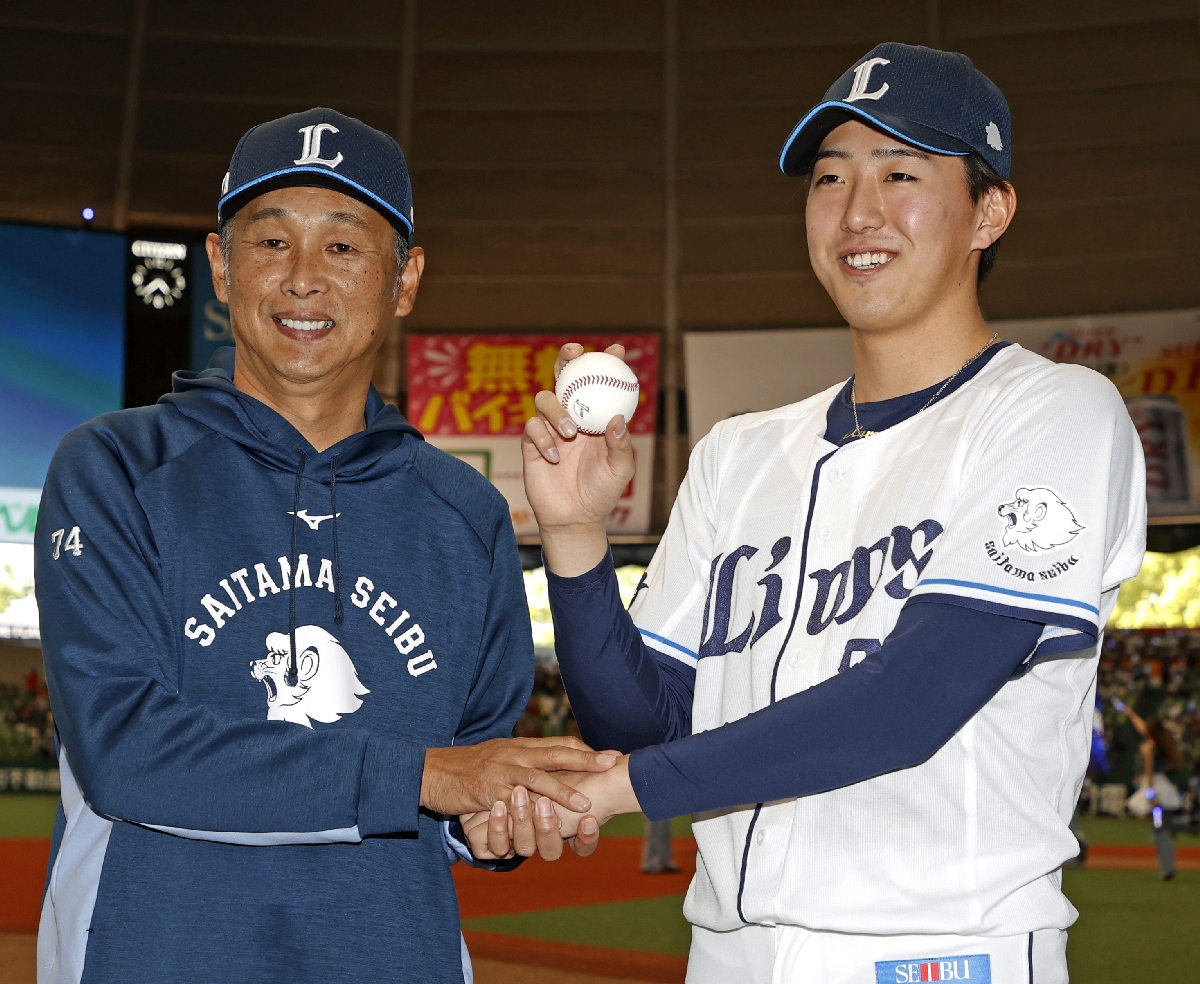　プロ初勝利を挙げ、西口監督（左）と写真に納まる西武・黒田＝ベルーナドーム