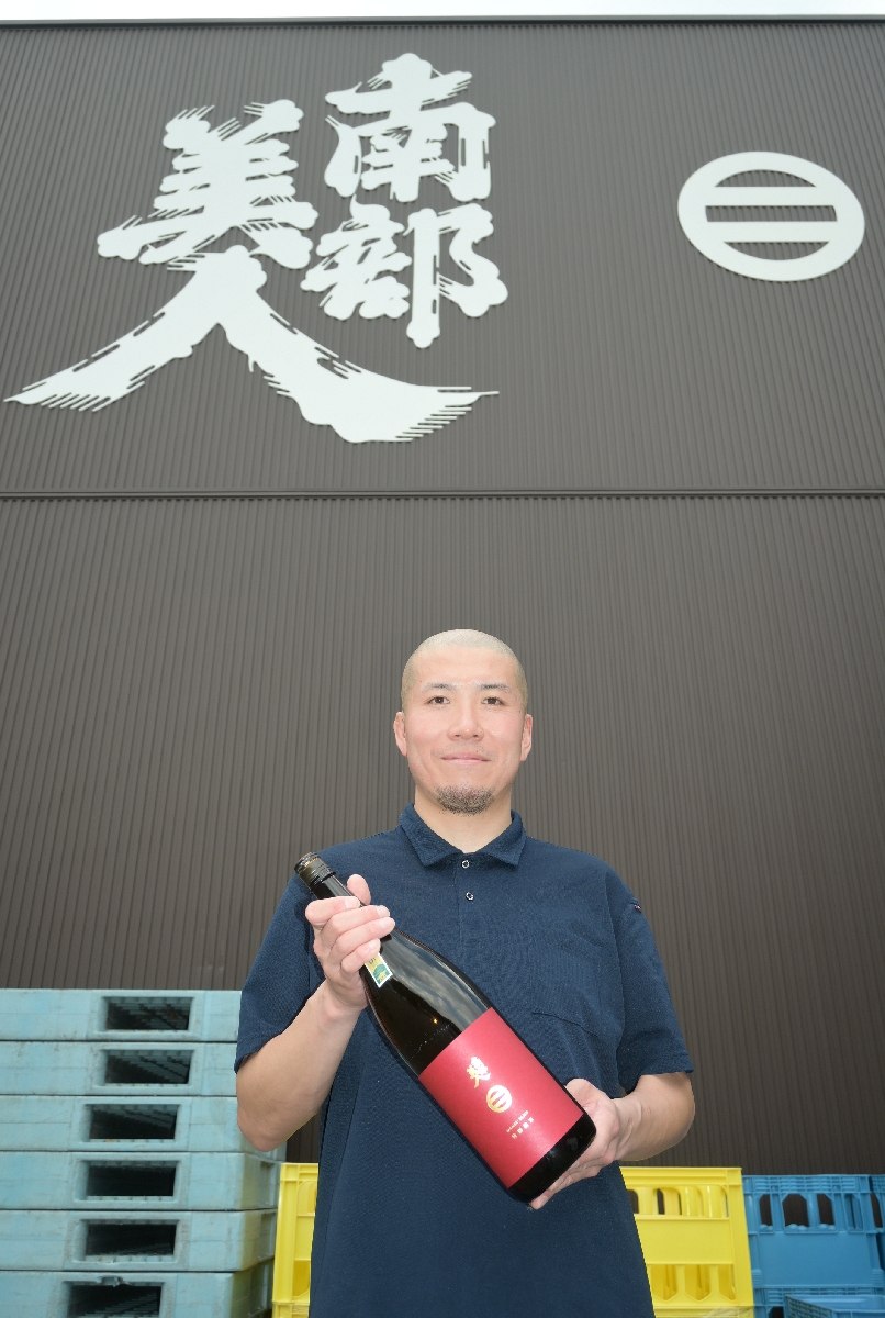 大賞の「南部美人 特別純米」を掲げる林敬宏さん=13日、二戸市