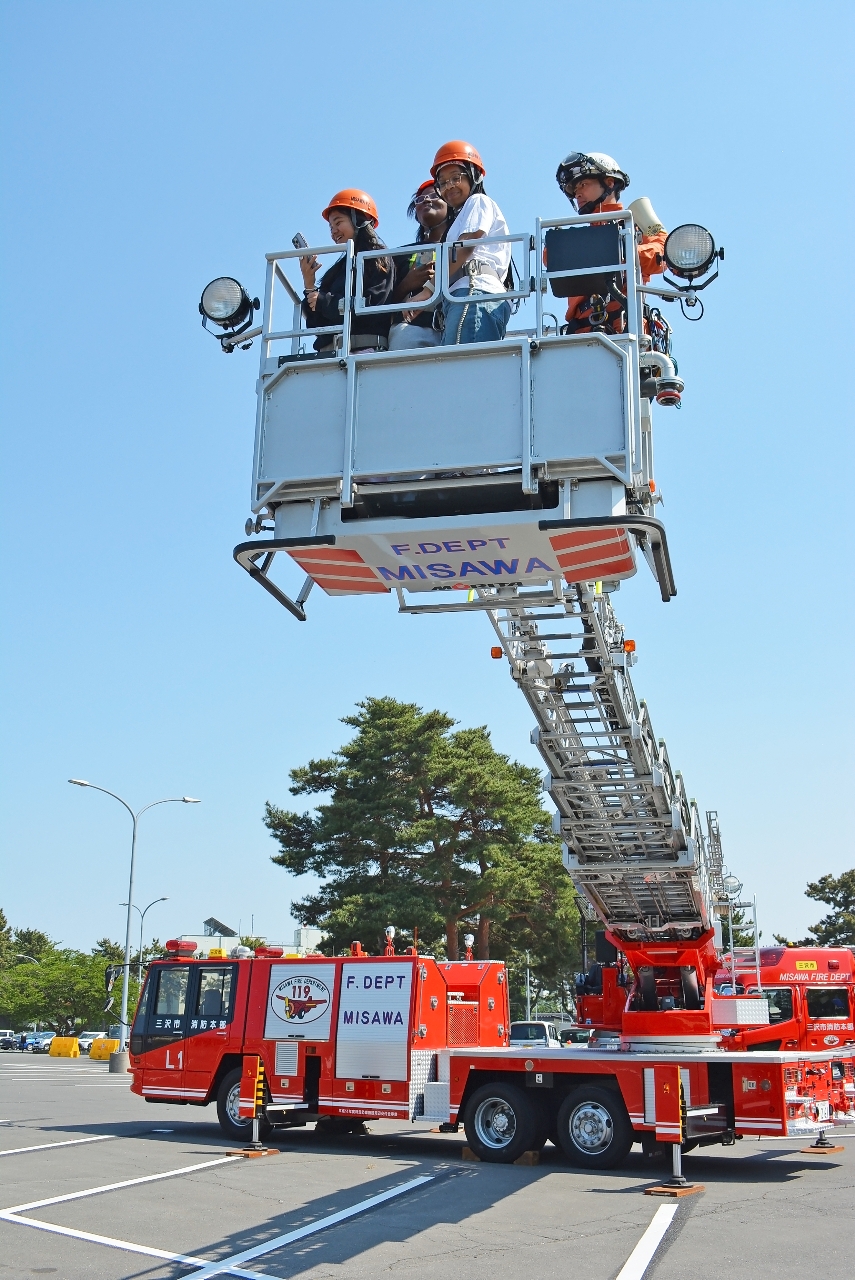 三沢市消防本部のはしご車に乗る子ども