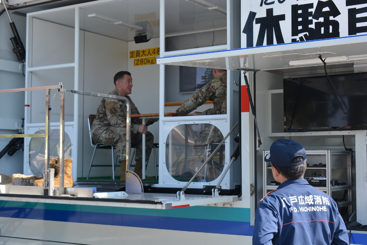 地震体験車で揺れを体感する米軍隊員