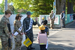 空自と米軍、笑顔で児童とハイタッチ　三沢で合同見守りボランティア