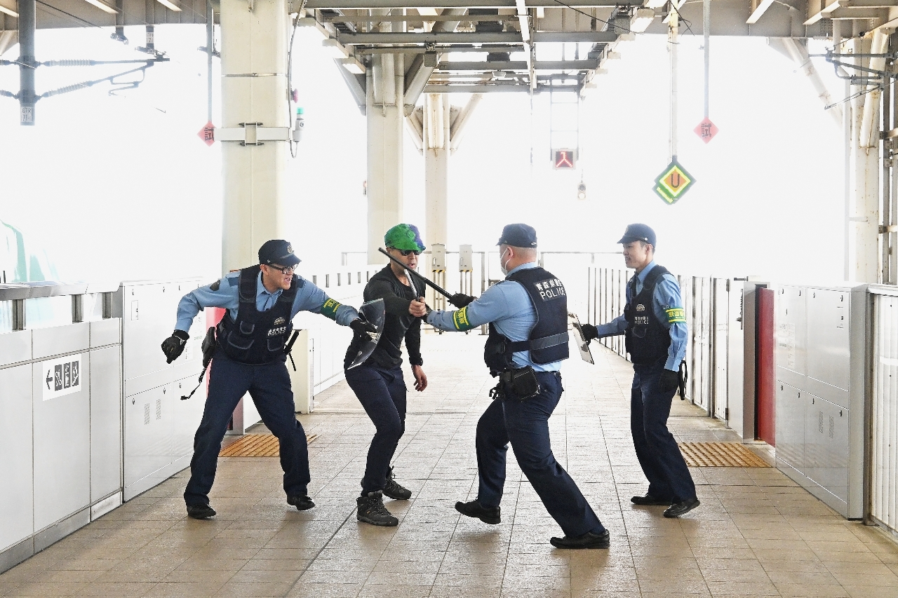 訓練で不審者役を制圧する警察官＝１９日、新青森駅