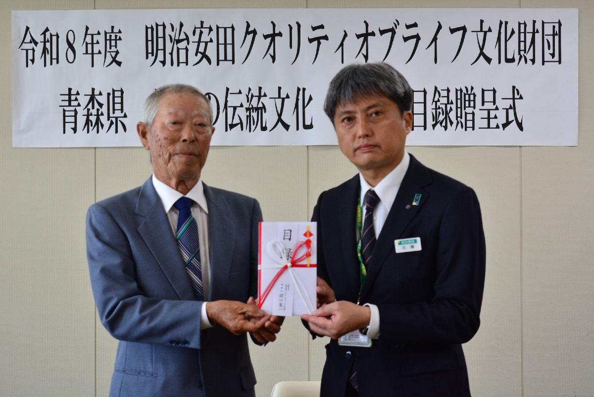 吉田恵一代表（左）に目録を手渡す佐藤恒寛支社長