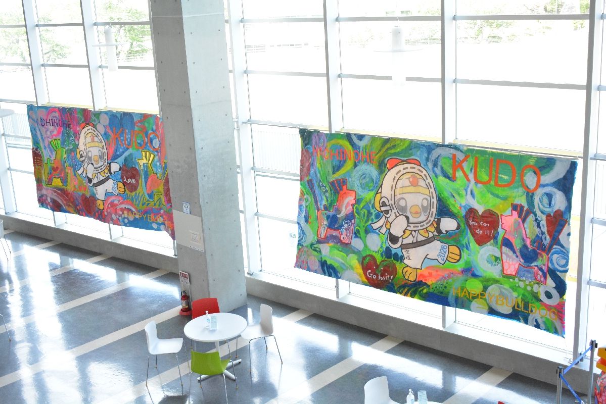 八戸市のマスコットキャラクター「いかずきんズ」や八幡馬が描かれた横断幕アート