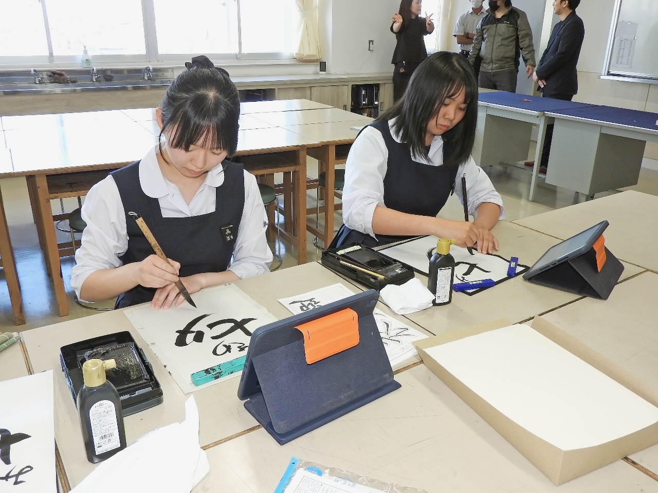 ポスター製作に向けて筆を走らせる生徒