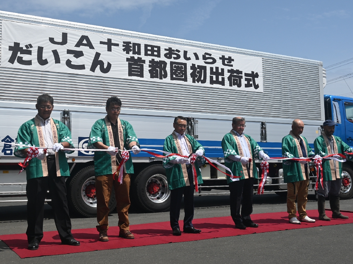 首都圏への出荷を祝いテープカットをする関係者=27日、おいらせ町