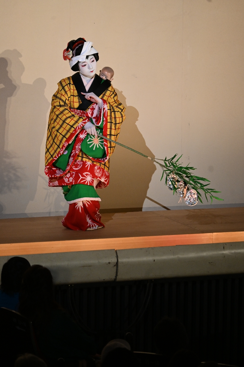 常磐津「三つ面子守」を披露する工藤果乃さん＝青森県立八戸高１年＝。笹の枝に着けたおかめ、えびす、ひょっとこの面を着けて踊り分ける