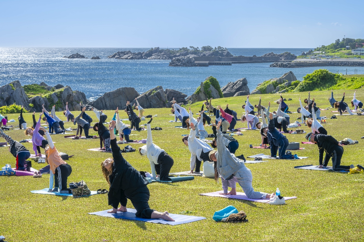 種差天然芝生地で朝ヨガを楽しむ参加者
