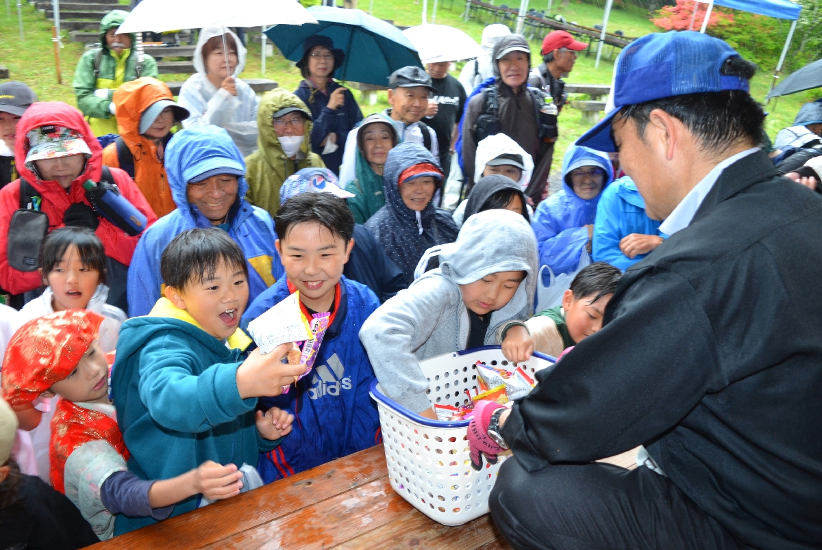 山頂広場周辺のステージで、配られた菓子に喜ぶ子どもたち