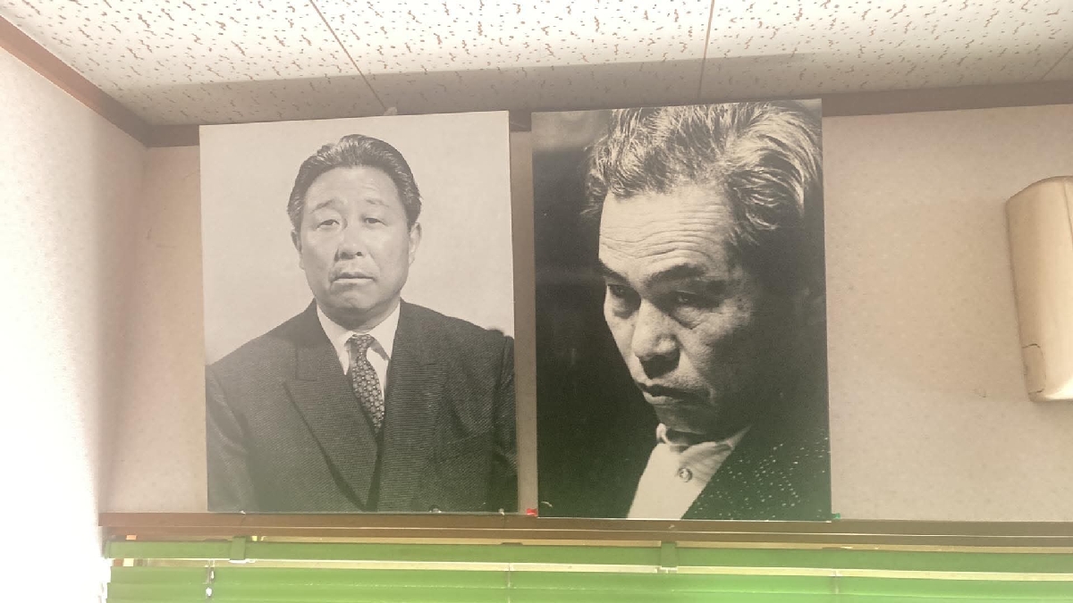 「日刊東北印刷」に飾られた新藤兼人監督(右)と佐藤不器さんの写真