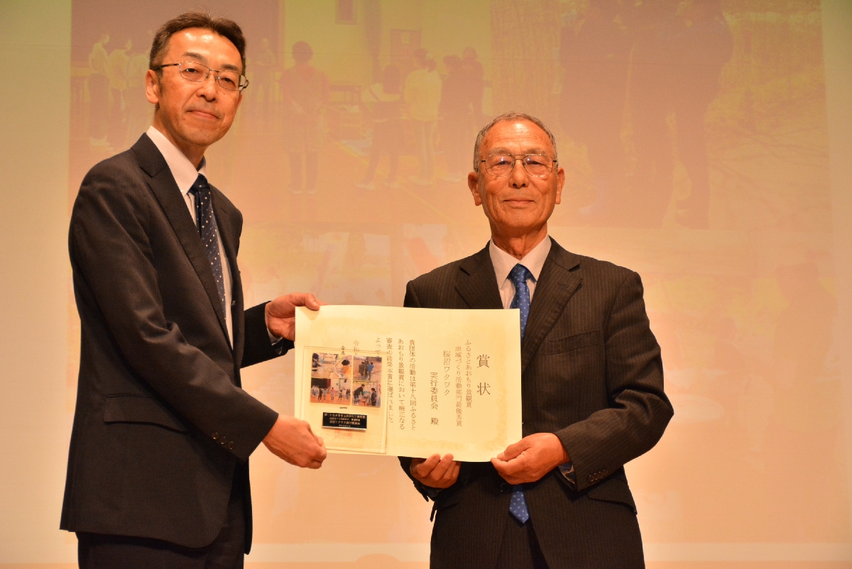 賞状を手にする桜沼ワクワク実行委の中里政廣副会長(右)と新屋孝文県土整備部長=2日、青森市