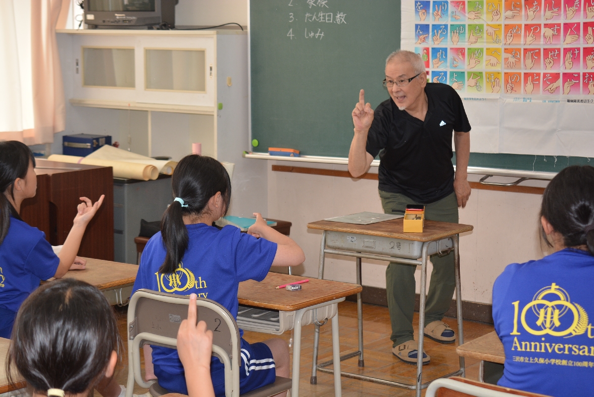 講師の荒谷淳一さんから手話を学ぶ児童
