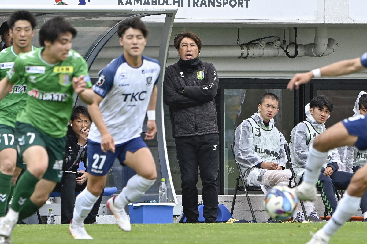 ベンチから声を出す高橋勇菊監督(中央)=5月24日、八戸市プライフーズスタジアム