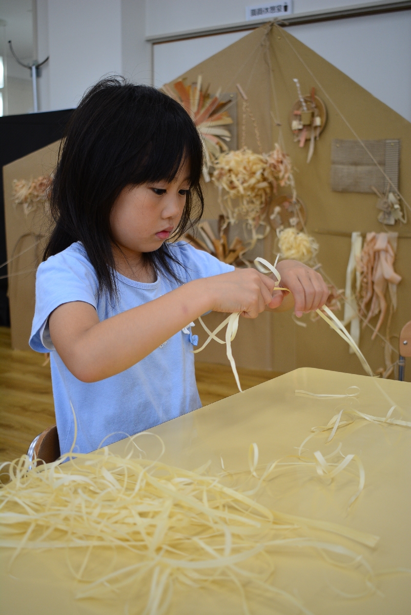 園児は、素材を割いたり束ねたりしてミニオーナメントを作った