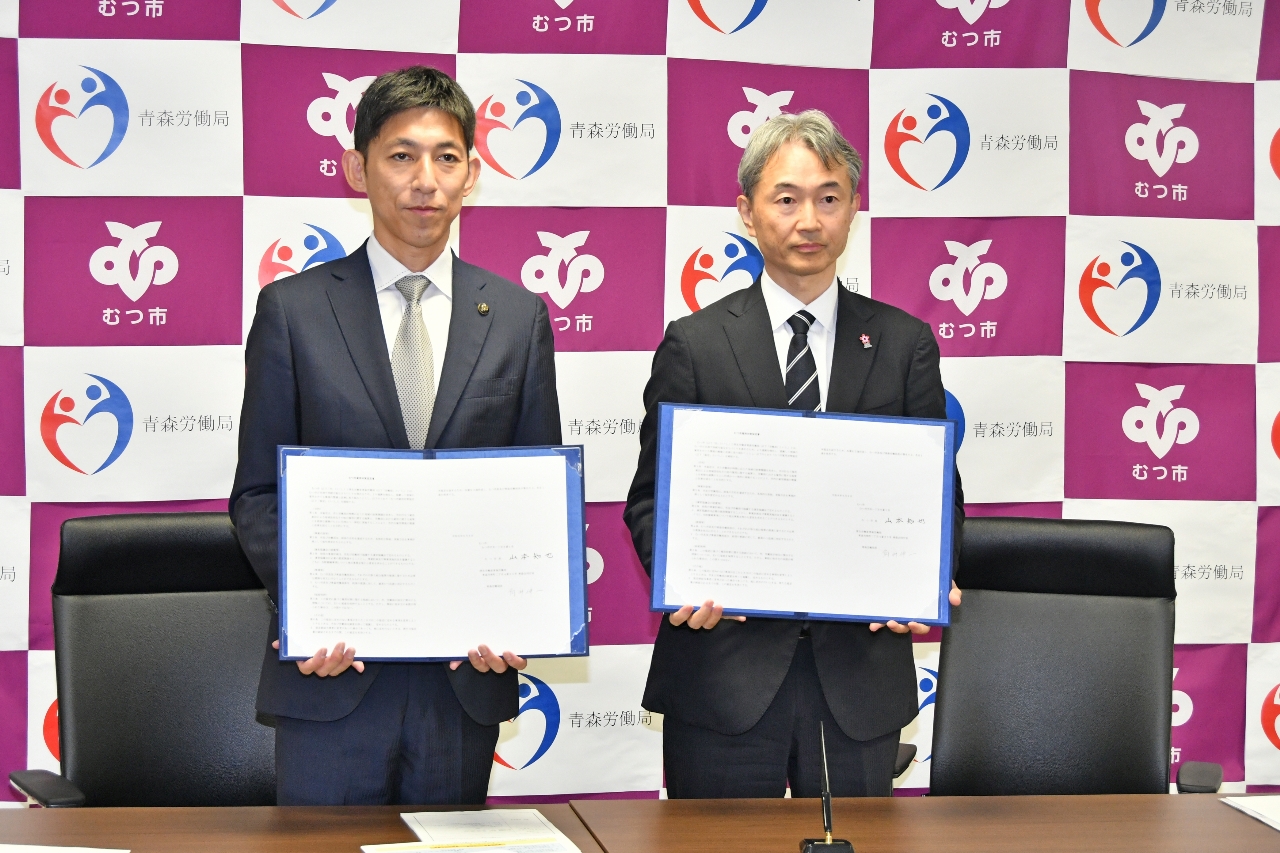 協定書を手にする角井伸一局長(右)と山本知也市長=8日、むつ市役所