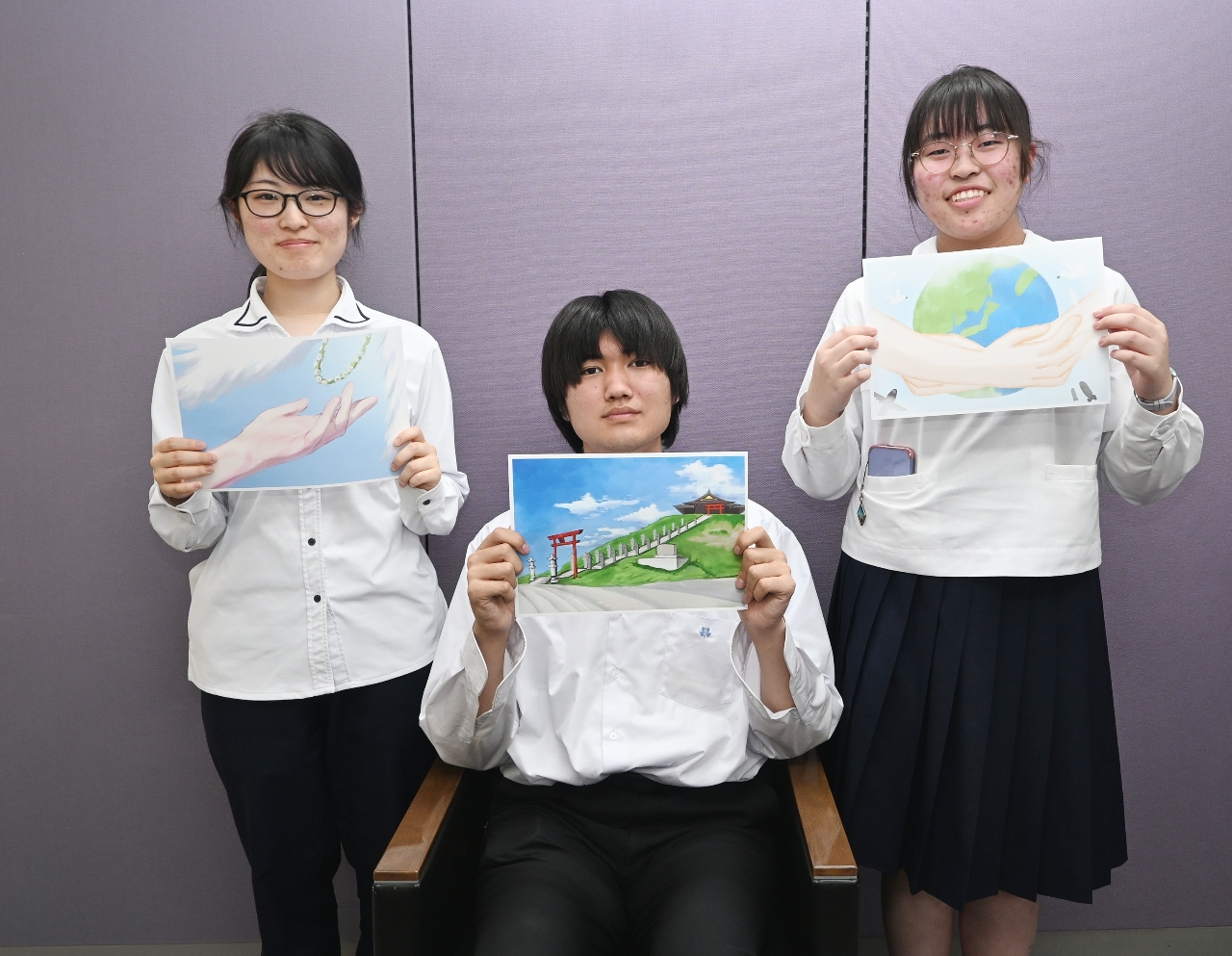 プロジェクトに参加した(左から)川嵜仁美さん、眞鍋義弘さん、佐藤来さん。川嵜さんと佐藤さんが描いた「平和」をイメージした絵を手にしている