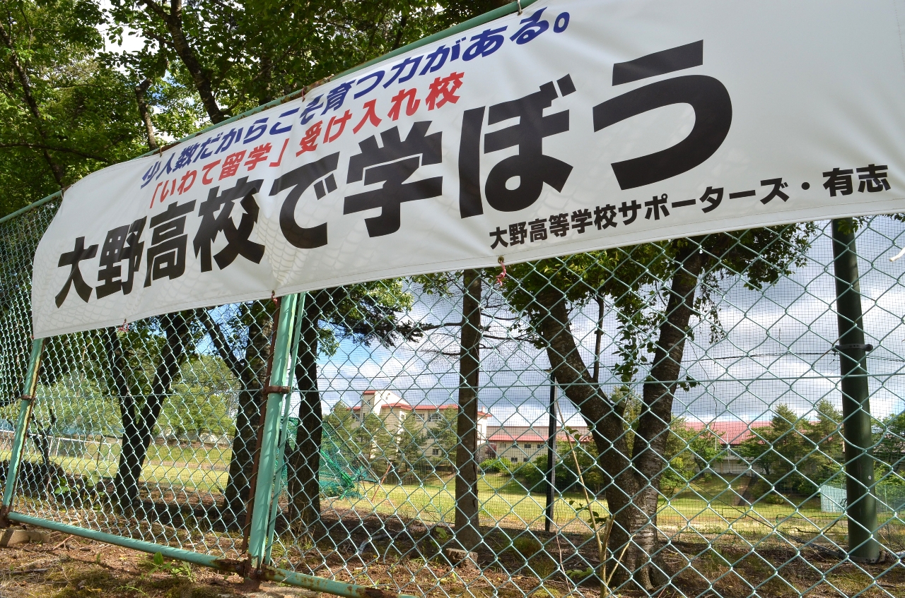 2027年度に生徒募集停止の方針が示された岩手県立大野高(奥)。地元有志が存続を呼びかける横断幕が掲げられている=9日、洋野町大野