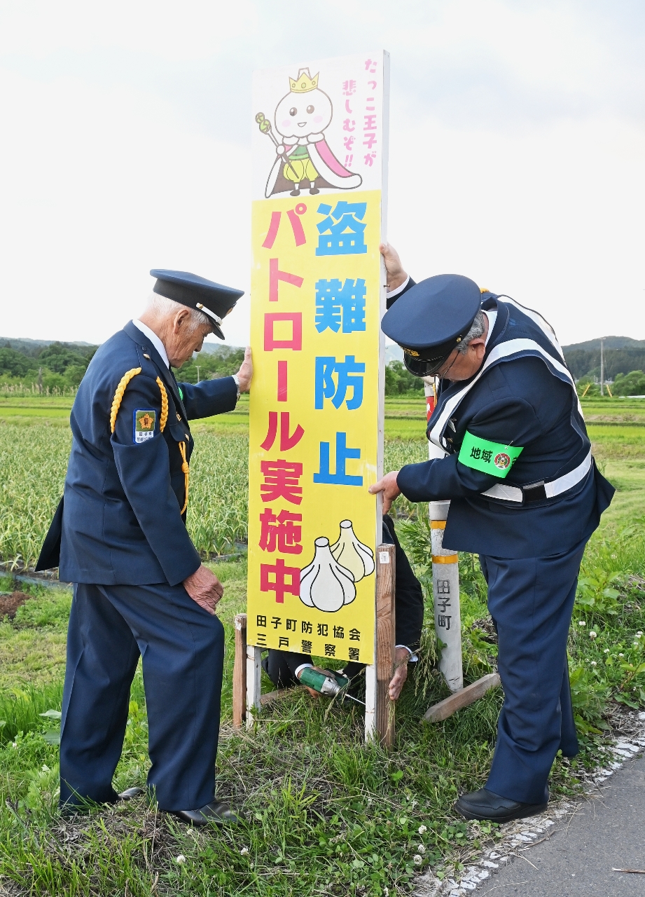 警戒を呼びかける看板を設置する防犯関係者