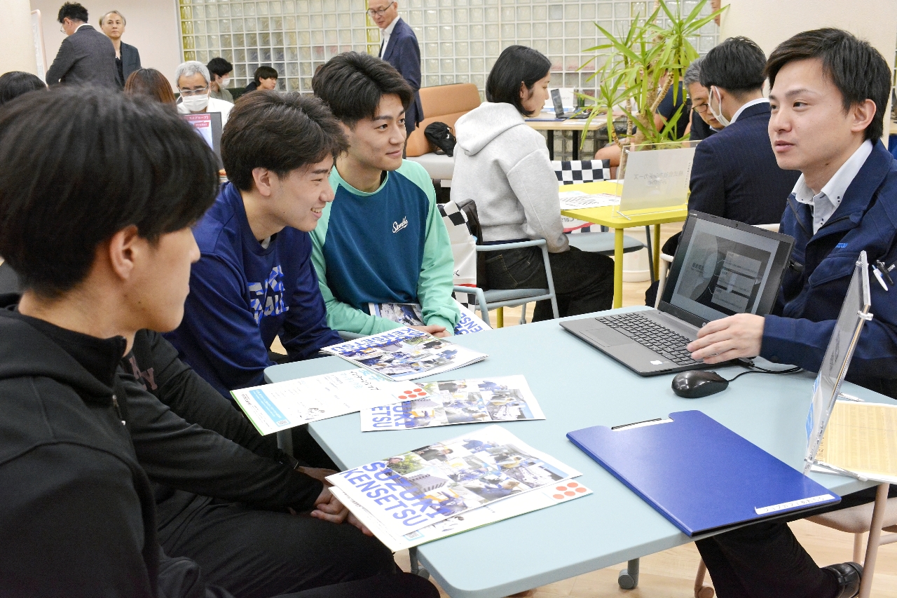 企業の担当者（右）から説明を受ける学生＝１０日、八戸学院大
