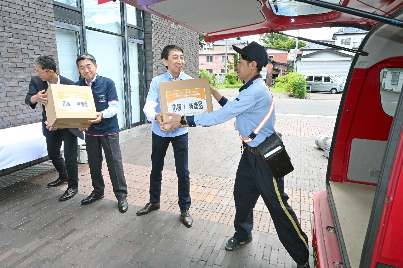 特産品を詰め込んだ段ボールを運ぶ沼沢修二町長(右から2人目)ら