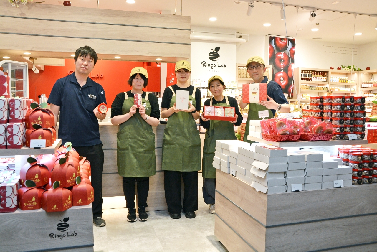商品をPRする「リンゴラボ」の関係者=10日、八戸市の八食センター