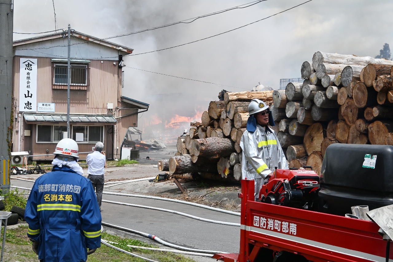 消火作業に当たる消防団員=11日午前11時40分ごろ、南部町