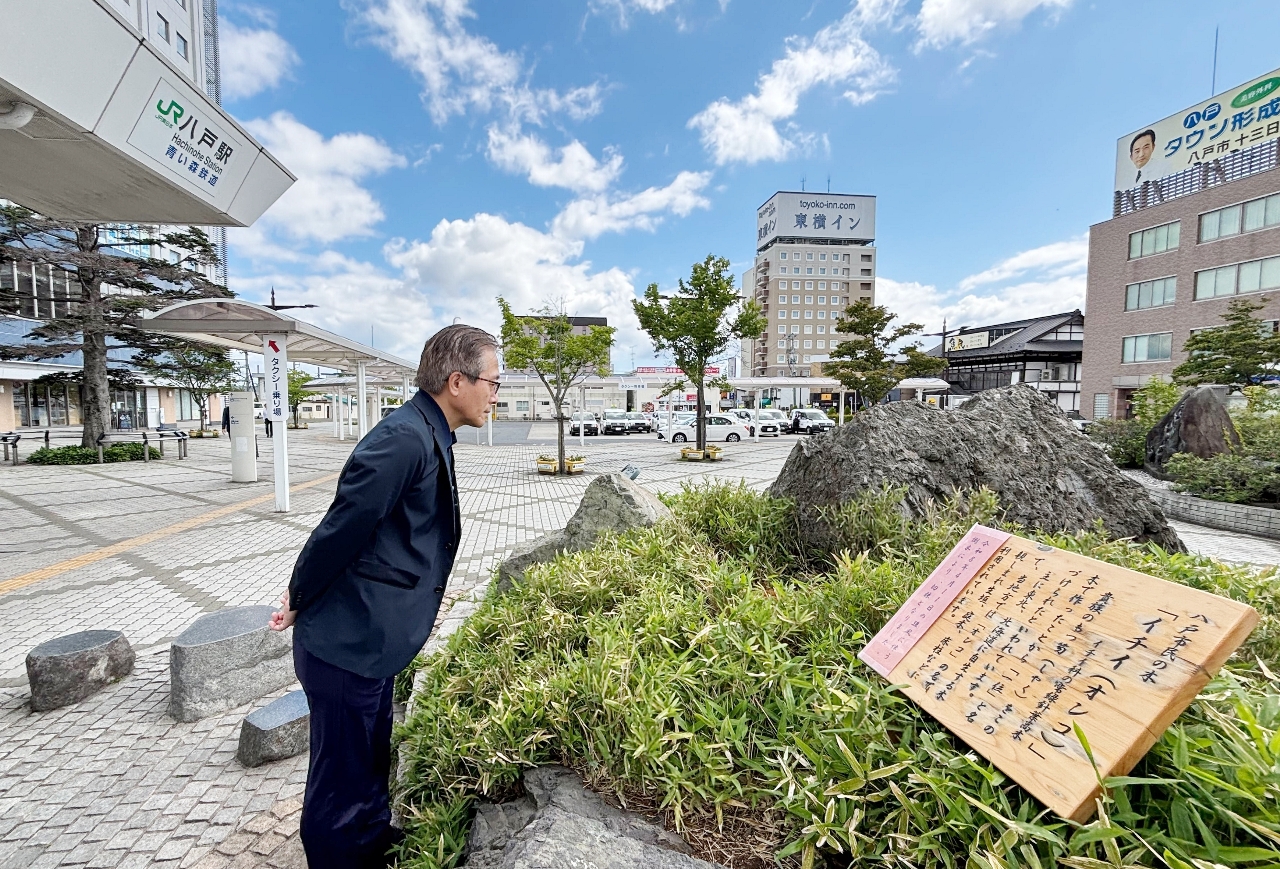 倒れたイチイの木があった場所を見つめる小笠原博仁会長=11日、八戸駅前