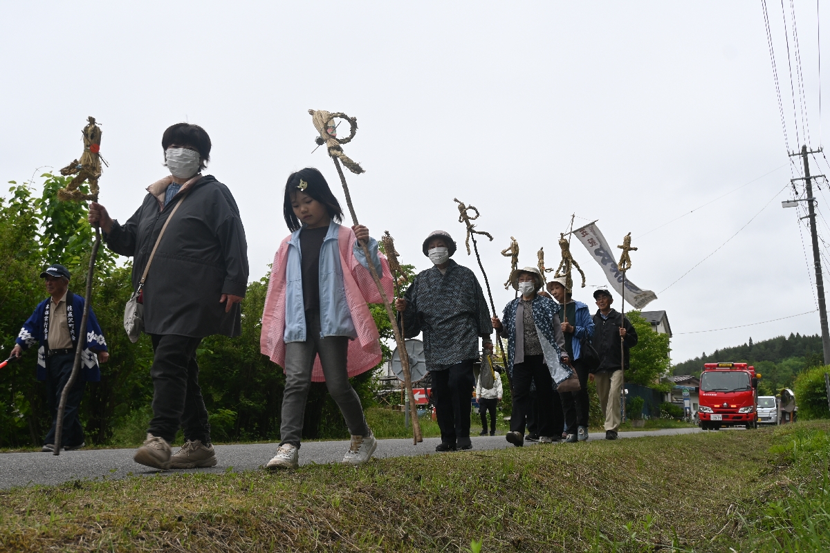 住民がわら人形をくくりつけた棒を手に地区内を練り歩いた「虫まつり」