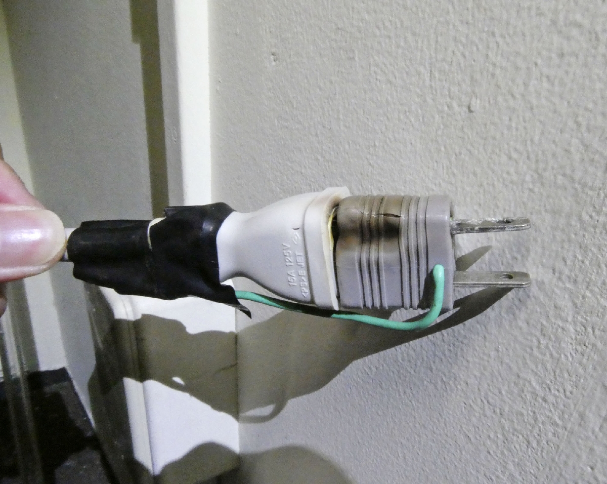 核燃料サイクル工学研究所で見つかった焦げたテーブルタップのプラグ=15日午前、茨城県東海村(日本原子力研究開発機構提供)