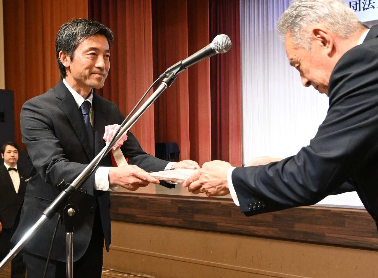 観光功労者表彰を受ける丹羽裕之理事長(左)=15日、青森市