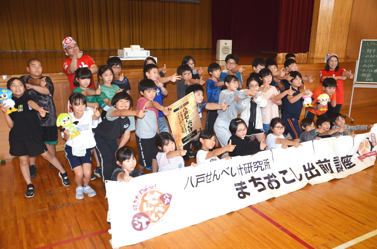 出前講座を受講し、記念撮影する児童ら
