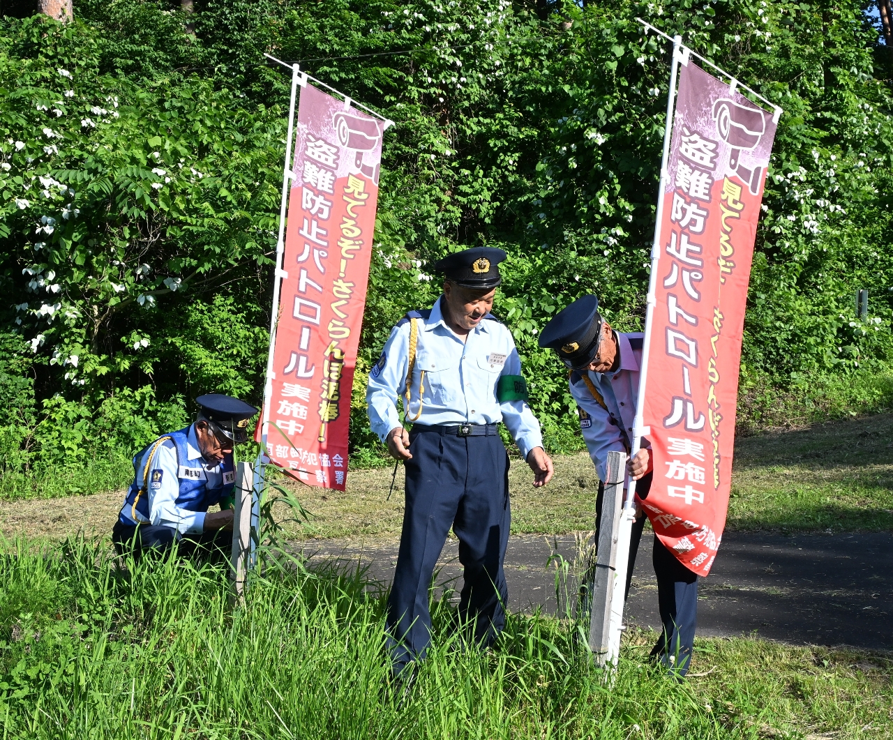 監視活動を伝えるのぼり旗を設置する防犯関係者