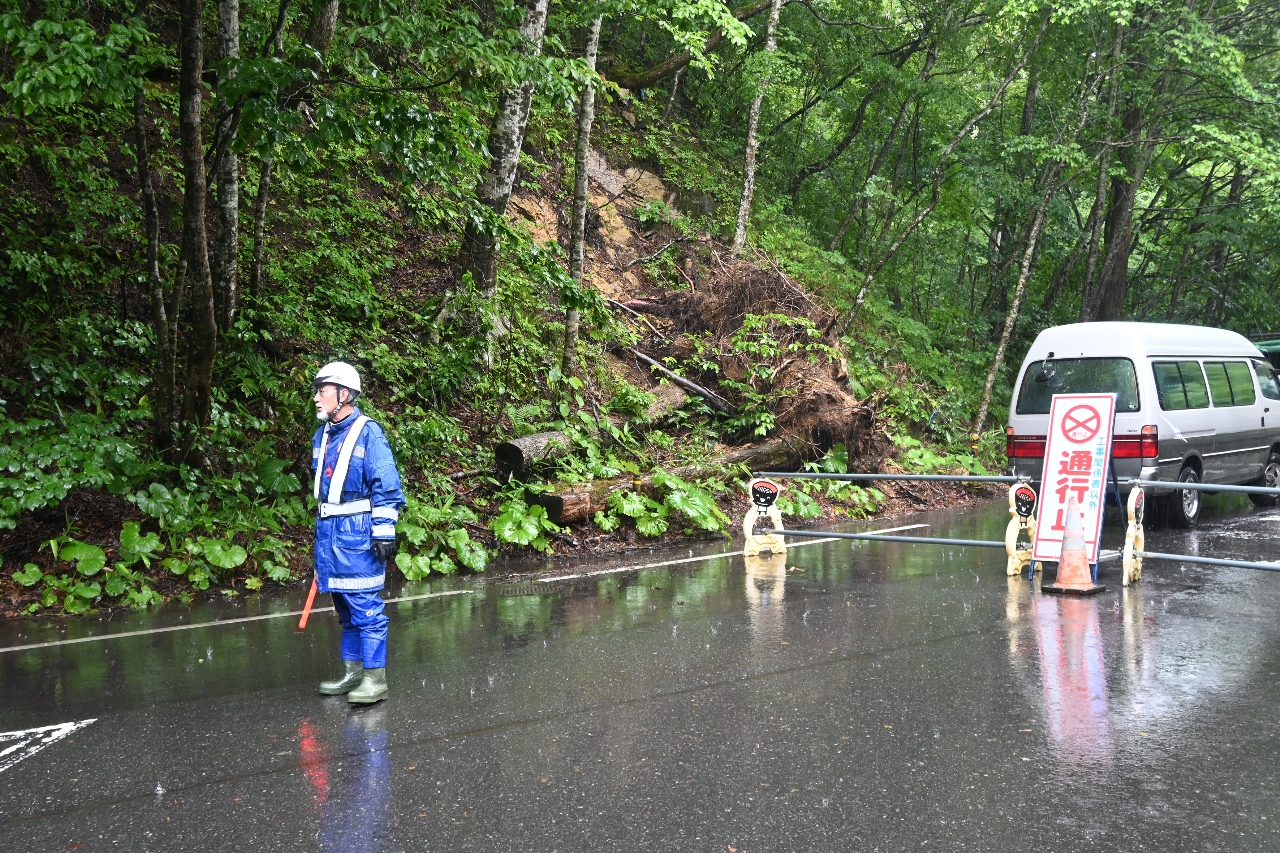 通行止めのバリケードが設けられた十和田市惣辺地区。道路脇で崩れている箇所もあった＝２２日午後０時半ごろ
