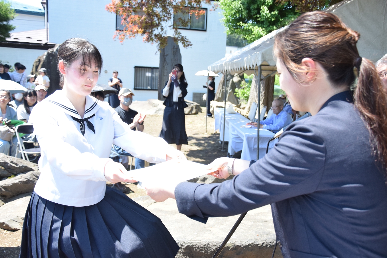 短歌選者の小瀬川喜井さん(右)から表彰状を受け取る入賞者=14日、八戸市の芭蕉堂公園