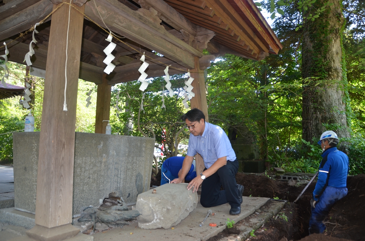 手水舎の被害状況を確認する栗谷川敏彦代表(中央)=24日、八戸市の長者山新羅神社