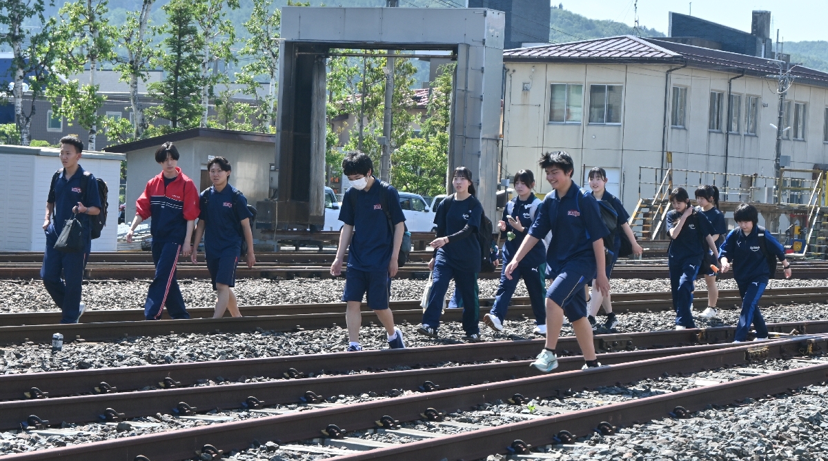 緊急停車した列車から降り、線路上を歩いて久慈駅に到着した高校生ら=25日午前8時50分ごろ、久慈市