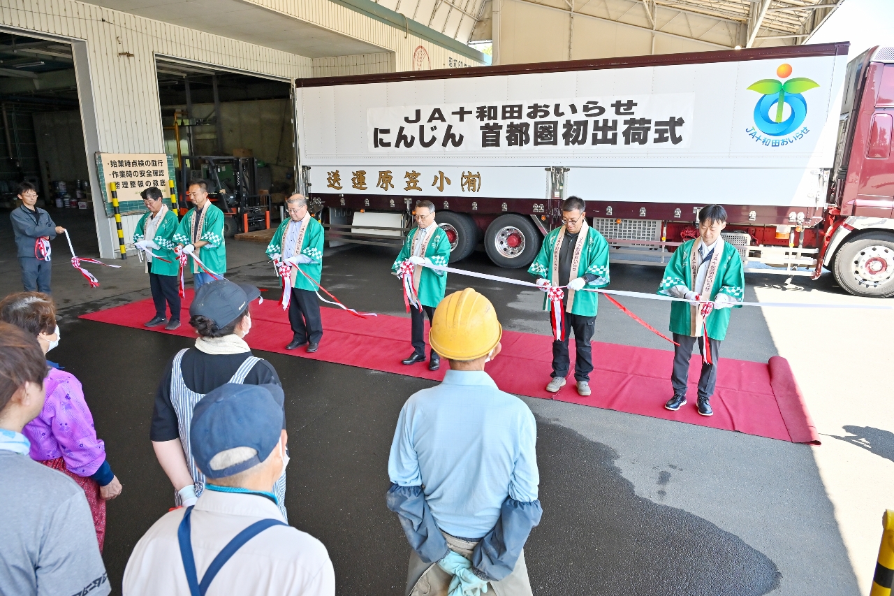 テープカットでニンジンの出荷を祝う関係者＝２５日、おいらせ町