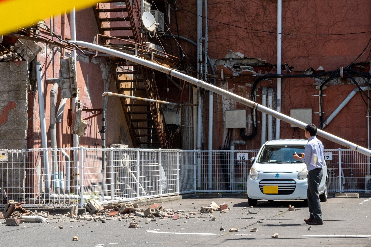 八戸市中心街のビルでは外壁が剝がれ、隣の駐車場敷地に破片が落ちるなどした=午前10時ごろ、八戸市長横町